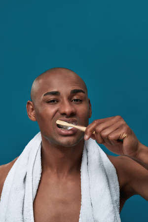 Relaxed multiracial person moving toothbrush on upper right teeth