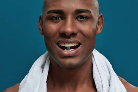 Charcoal tablet between teeth of a man with towelの写真素材