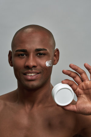 Cosmetic cream box in multiracial man fingers