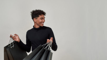 Smiling young african american guy holding paper packets