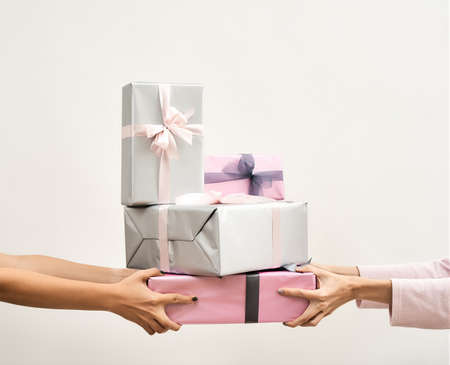 Present for Mothers Day, birthday, New Year, Christmas. Female hands holding colorful gift boxes...