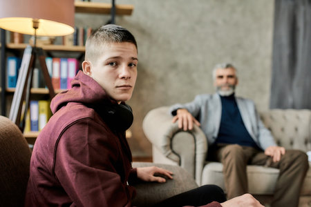 Calm teenager during session with psychotherapist in officeの写真素材