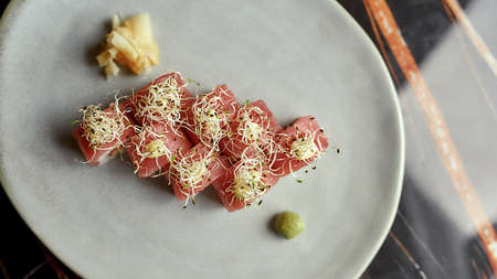 Set of delicious sushi roll set decorated with sprouts served on white plate with wasabi and ginger....