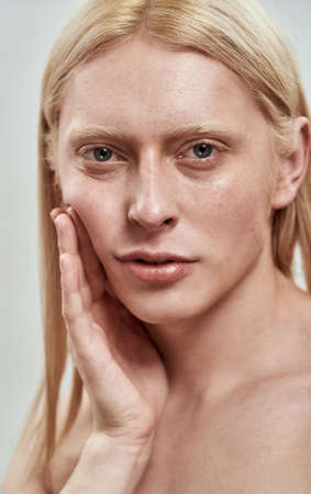 Portrait of handsome young caucasian man tightening cheekの写真素材