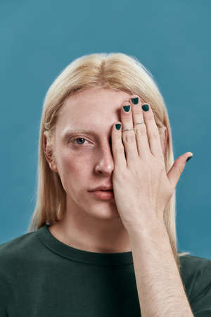 Man holding manicured hand with painted nails on eye