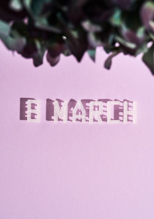 Happy Womens day. Text 8 MARCH and flowers on pastel pink background, vertical shotの写真素材