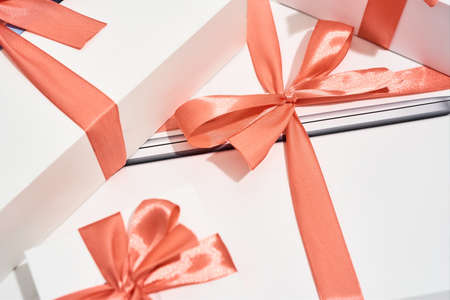 Happy birthday. Close shot of a pile of white gift boxes of different sizes with red bowsの写真素材