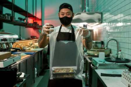 Asian restaurant chef standing with food