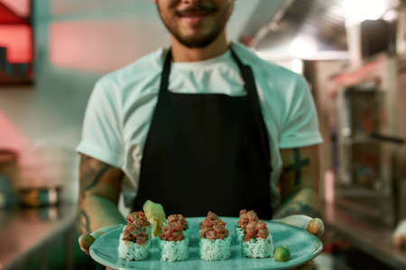 Male chef holding sushi in his handsの写真素材