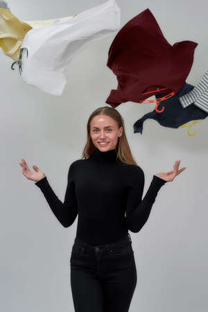 Smiling young caucasian girl standing under flying clothes