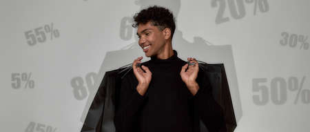 Man on background with percents holding shopping bagsの写真素材