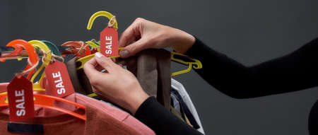 Woman taking dress from hanger with sale tagsの写真素材