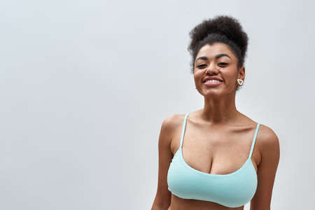 Portrait of beautiful sexy young mixed race woman wearing blue underwear smiling at camera while posing isolated over light backgroundの写真素材