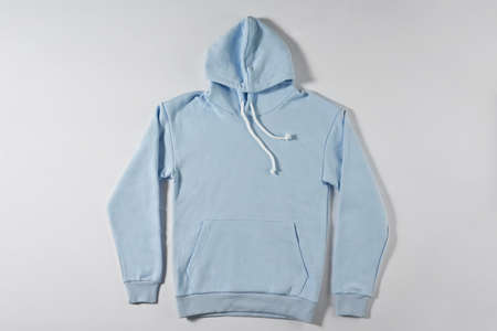 Blue jacket with a hood lies on a light background