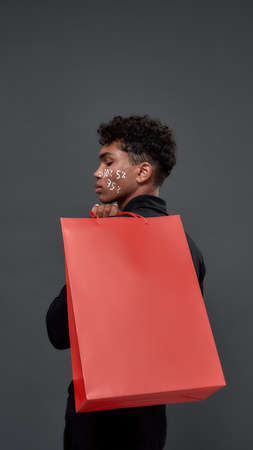 Young african american man holding paper bag mockupの写真素材