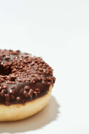 Mmm, so yummy. Close up shot of a freshly baked delicious chocolate donut with sprinkles on white backgroundの写真素材
