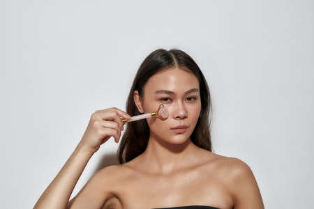 Stylish girl posing with a roller in her handの写真素材