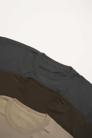 Close up of three basic multicolored shirts on grey background