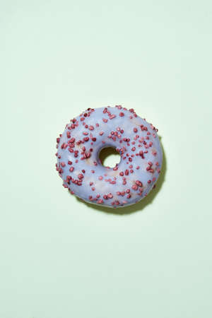 Sugar Addiction. Freshly baked delicious donut with colorful sprinkles and purple sugar glaze...