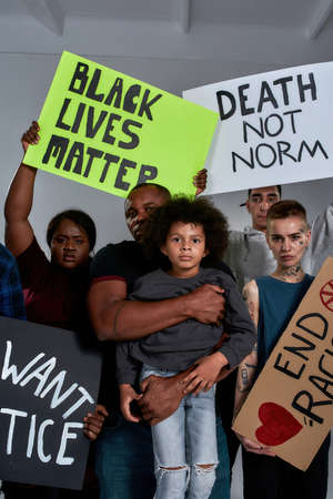 Little african american boy with people holding banners