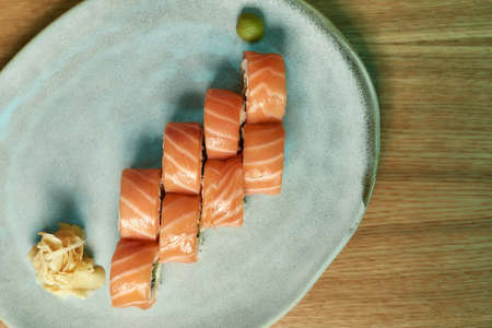 Top view of Philadelphia sushi rolls with salmon, avocado, cream cheese laid out on a white plateの写真素材