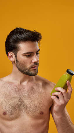 Bearded man with naked torso holding smoothiesの写真素材