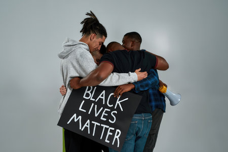 Rear view of young multiracial people hugging each other
