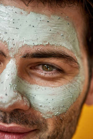 Cropped shot of young bearded man with green maskの写真素材