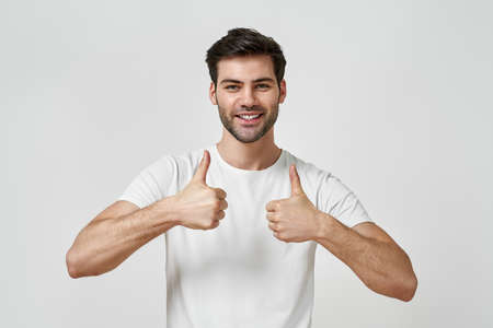 Young man wearing t-shirt raise two thumbs upの写真素材