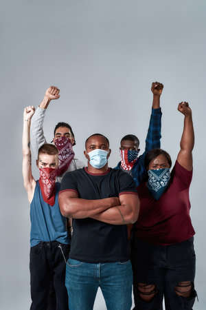 Young multiracial protestors standing with raised hand