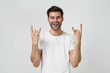Man wearing t-shirt doing rock symbol