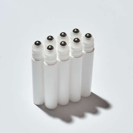 Closeup shot of tubes for eye roller beauty product isolated over white background with reflection
