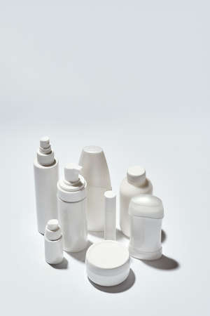 Different white bottles and containers for hygiene, health and beauty products isolated over white background with reflectionの写真素材