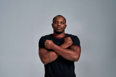 Young african american man with crossed hands on chest