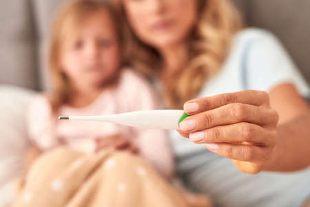 A picture of a mother checking her daughters temperature
