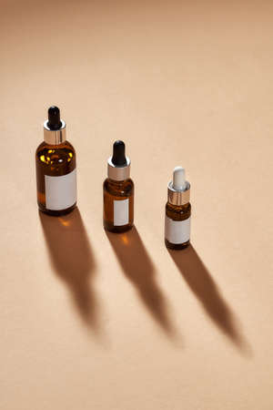Set of glass bottle cosmetics with dropper isolated on beige backgroundの写真素材