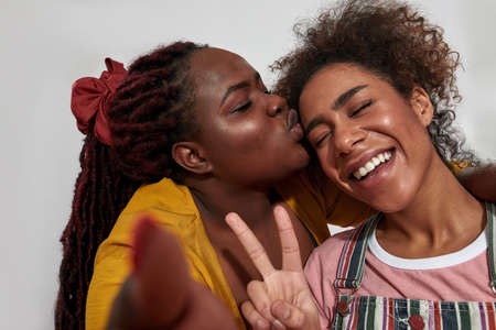 A black woman is kissing a black woman both are very happyの写真素材