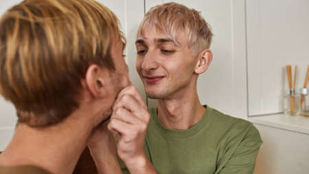 Cheerful homosexual couple of men in modern kitchen