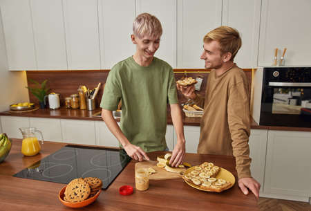 Cheerful same sex couple of men preparing snacks