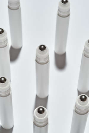 Close up of tubes for eye roller beauty product isolated over white background with reflectionの写真素材
