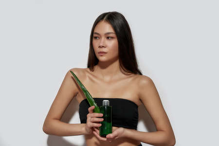Beautiful young asian girl holding aloe leaf and lotionの写真素材