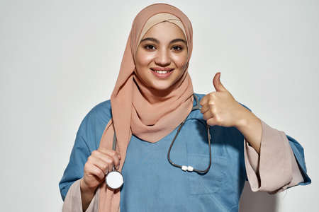 Arabian woman in doctor outfit showing thumb upの写真素材