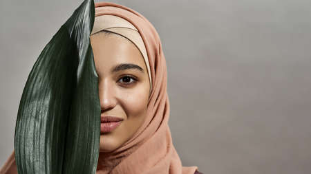 Portrait of young arabian woman covering her face