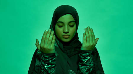 Young arabian girl in dark hijab holding bare hands