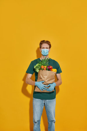 Courier holding packet with fresh vegetablesの写真素材