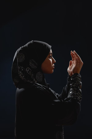 Young arabic woman in hijab looking at open palmsの写真素材