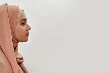 Young arabian girl in traditional hijab posing sideways