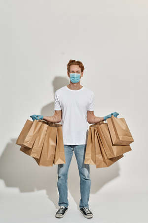 Delivery man who has a lot of paper bags hung on his hands