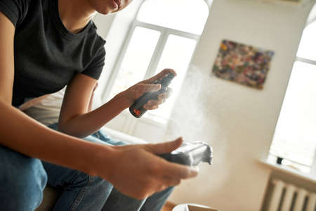 Picture of a young woman disinfecting game controllerの写真素材