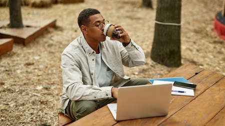Young african american man working on laptop outdoors